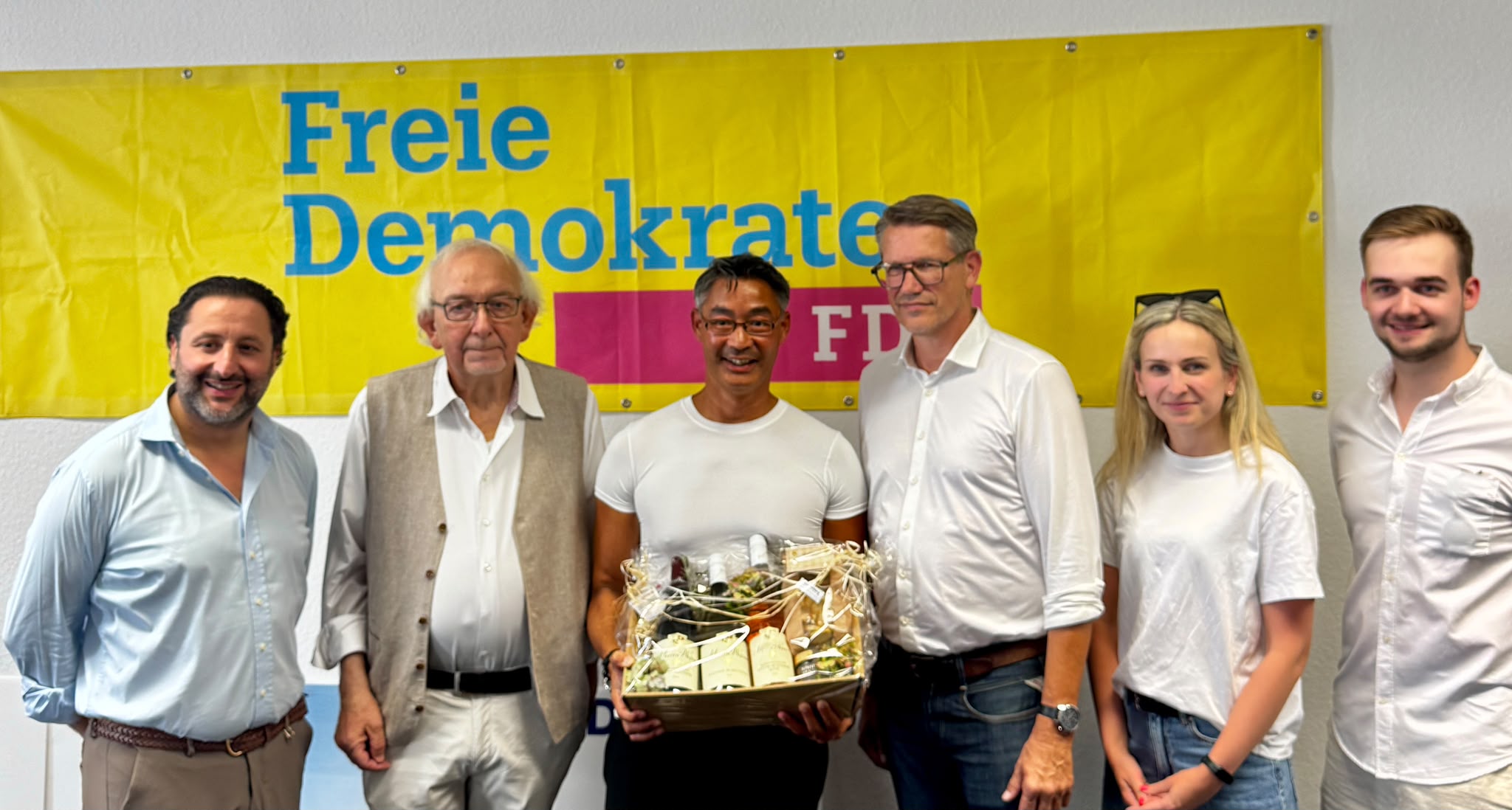 Yilmaz Mutlu, Dr. Philipp Rösler und weitere Mitglieder des FDP-Kreisverbandes stehen vor einem FDP-Banner in der neuen Kreisgeschäftsstelle.