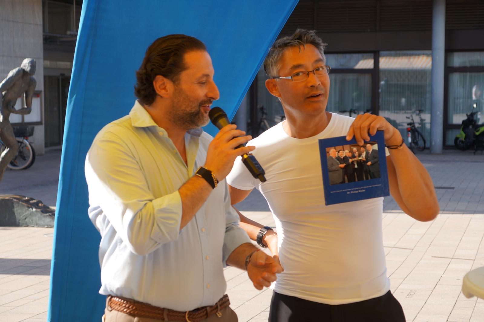 Yilmaz Mutlu und Dr. Philipp Rösler zeigen bei der Eröffnung eine gemeinsame Erinnerung.